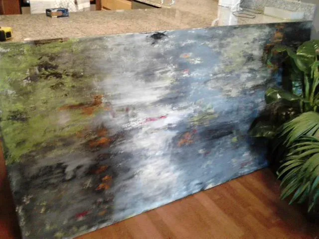 Abstract painting in blue, gray, and rust tones photographed in the studio