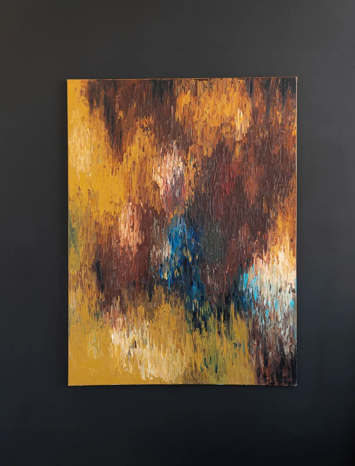 Abstract painting with layered gold, burgundy, blue, and warm earth tones