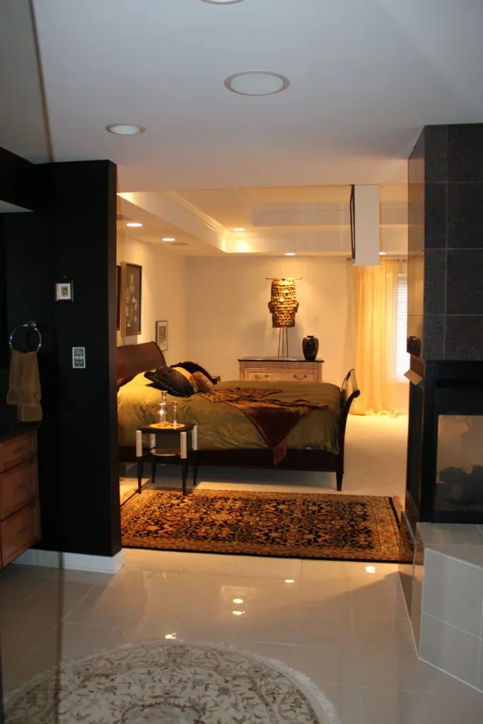 Bedroom with dark wood furnishings, ambient lighting, and a sculptural accent