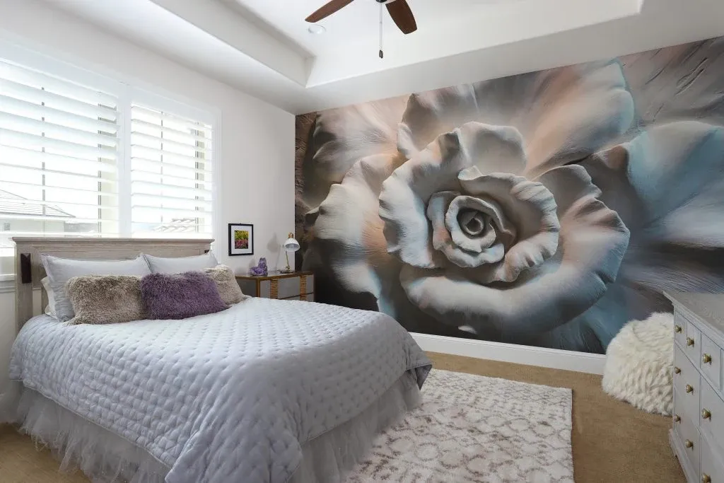 Bedroom featuring an oversized floral wall mural and upholstered bed