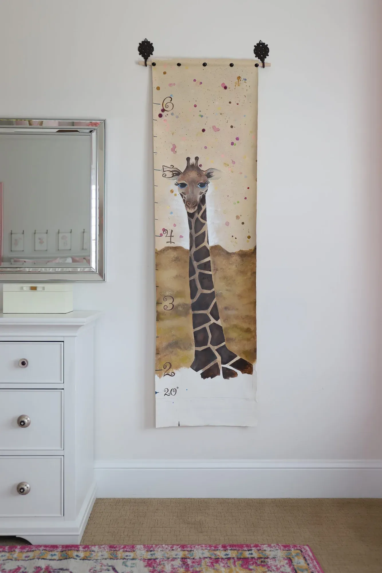 Hand-painted giraffe growth chart hanging in a child’s room