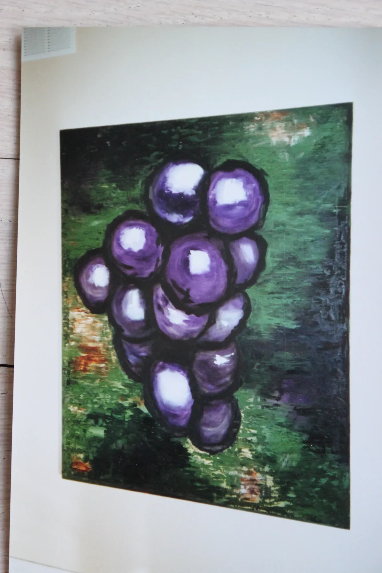 Painting of a cluster of purple grapes on a green background