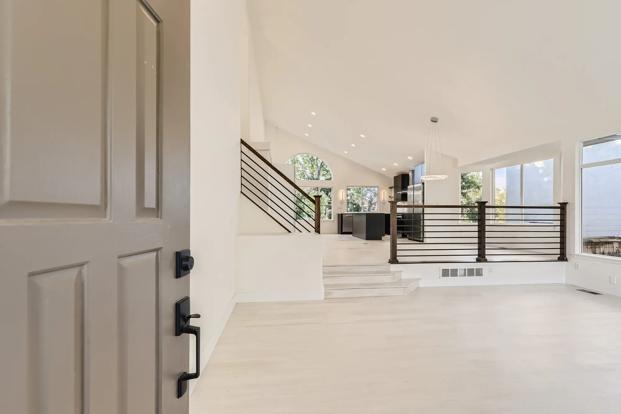 Bright foyer with a sweeping staircase and modern metal railing