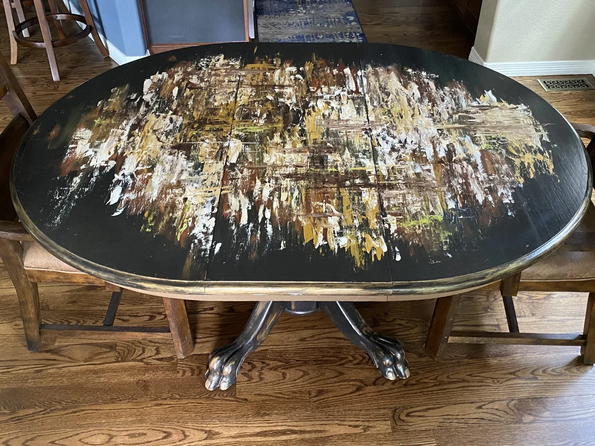 Oval table with a hand-painted abstract gold and black surface